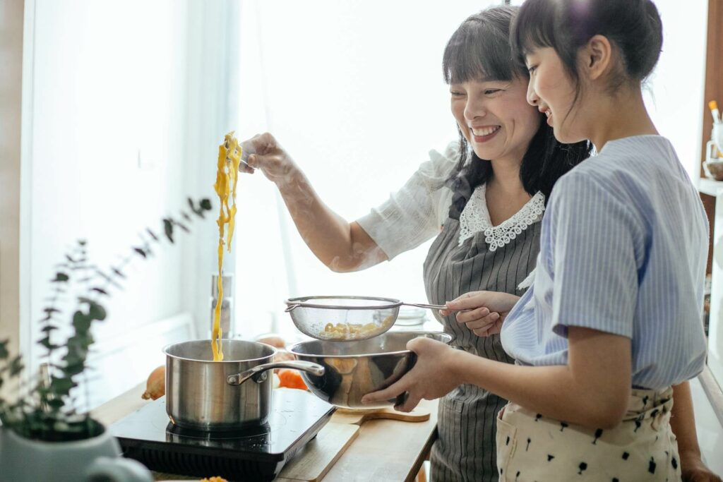 mother cooking and talking with teen daughter