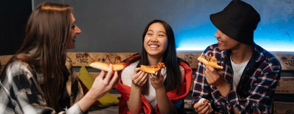 teens eating pizza and hanging out