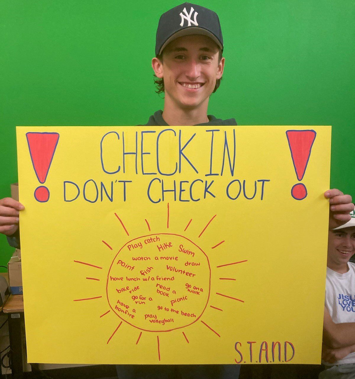 Student holding Check in, check out sign